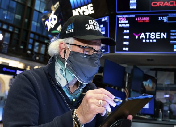 지난 24일(현지시간) 미국 뉴욕 뉴욕증권거래소(NYSE)에서 한 중개인이 '다우 30000'이라고 적힌 모자를 쓰고 거래를 하고 있다. (사진=AP뉴시스)